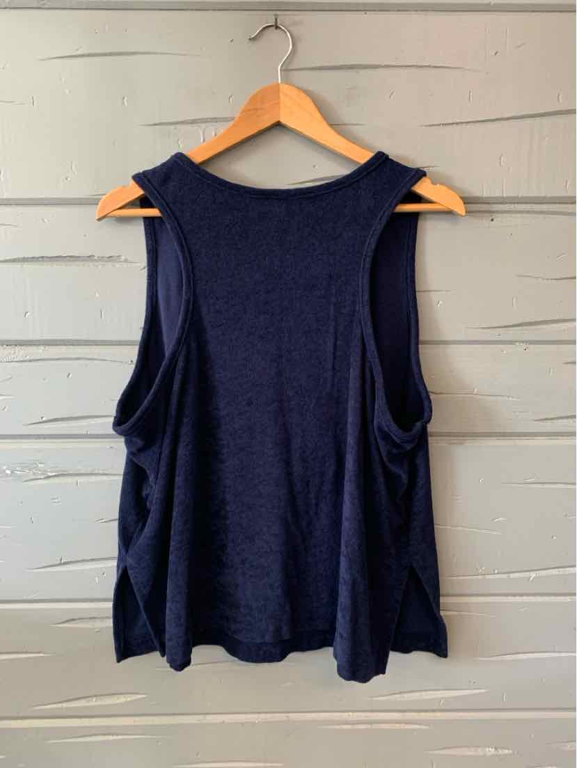 Navy blue sleeveless tank top with wide armholes, soft knit fabric, loose fit, hanging on wooden hanger.