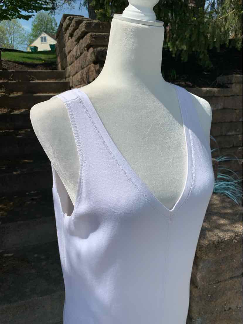 White sleeveless knit top with deep V-neck and wide shoulder straps on mannequin.