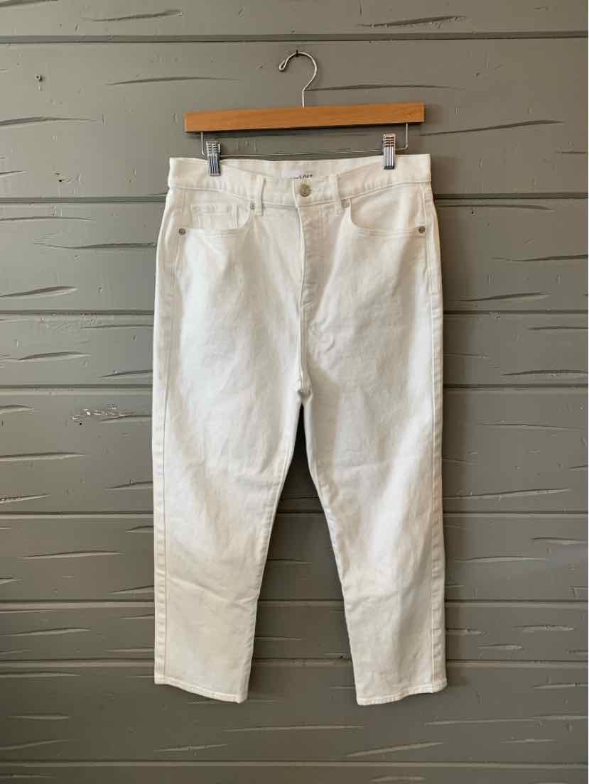 White denim jeans with a relaxed fit, front and back pockets, and a high waist hanging on a wooden hanger.
