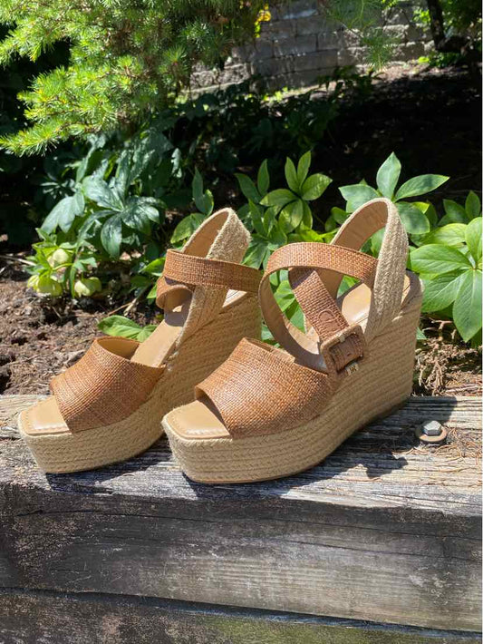 Tan wedge sandals with crisscross straps and adjustable ankle buckle, woven jute platform sole.