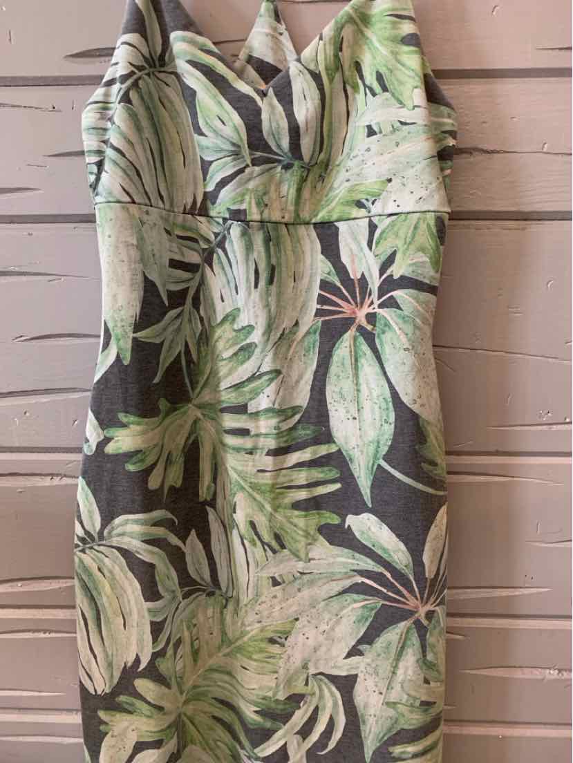 Sleeveless green tropical print dress with fitted bodice and V-neckline.