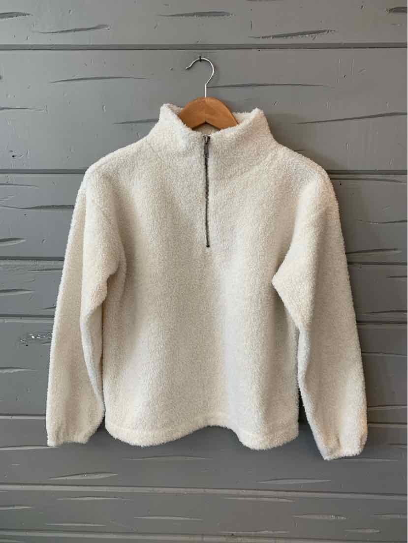 Cream-colored sherpa fleece pullover with half-zip and high collar on wooden hanger.