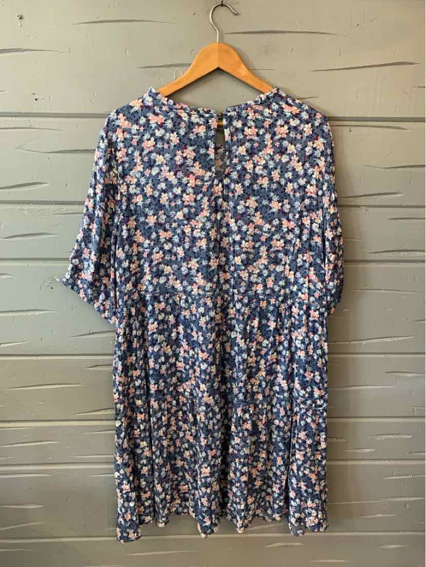 Blue floral knee-length dress with quarter sleeves and a loose, flowy fit on a wooden hanger.