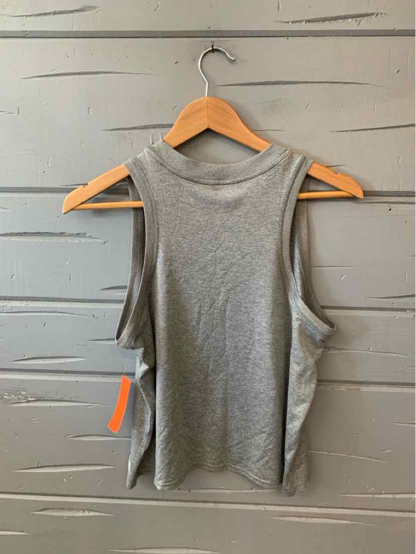 Light gray sleeveless tank top with wide armholes and a high neckline hanging on wooden hanger.