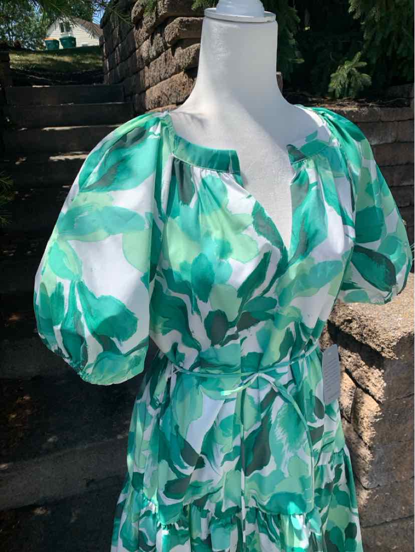 Green and white leaf print dress with puff sleeves and fitted waist belt.