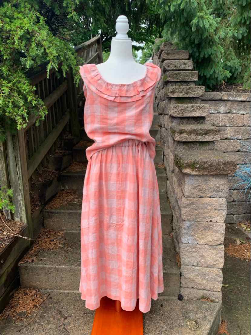 Coral and white gingham sleeveless dress with ruffled neckline and gathered waist.