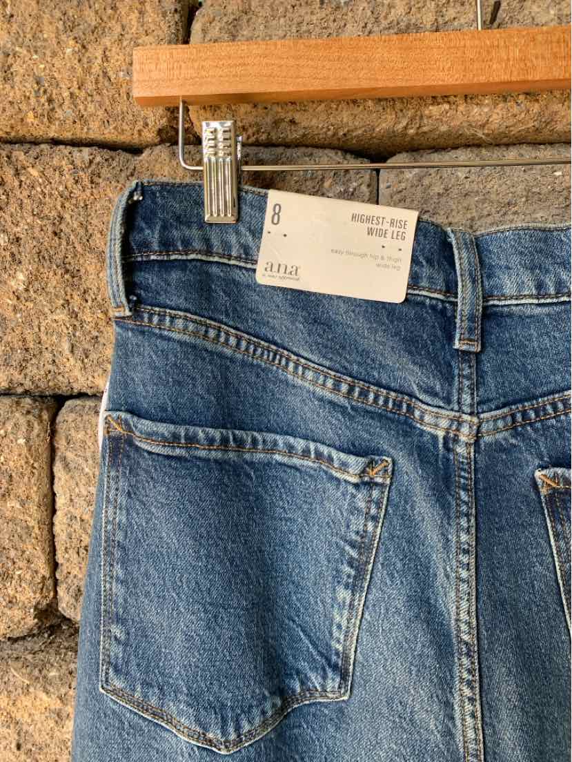 Back view of blue denim jeans with contrast stitching, a large pocket, belt loops, and a size 8 tag.