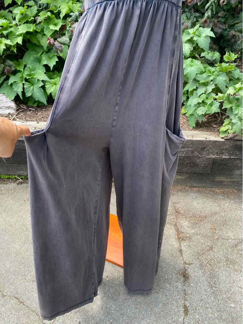 Dark gray high-waist wide-leg pants with elastic waistband and side pockets, made from soft fabric.