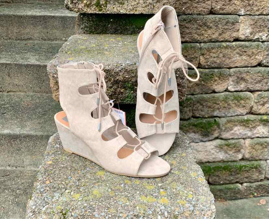 Beige suede gladiator wedge sandals with open toes and lace-up front, size 8.