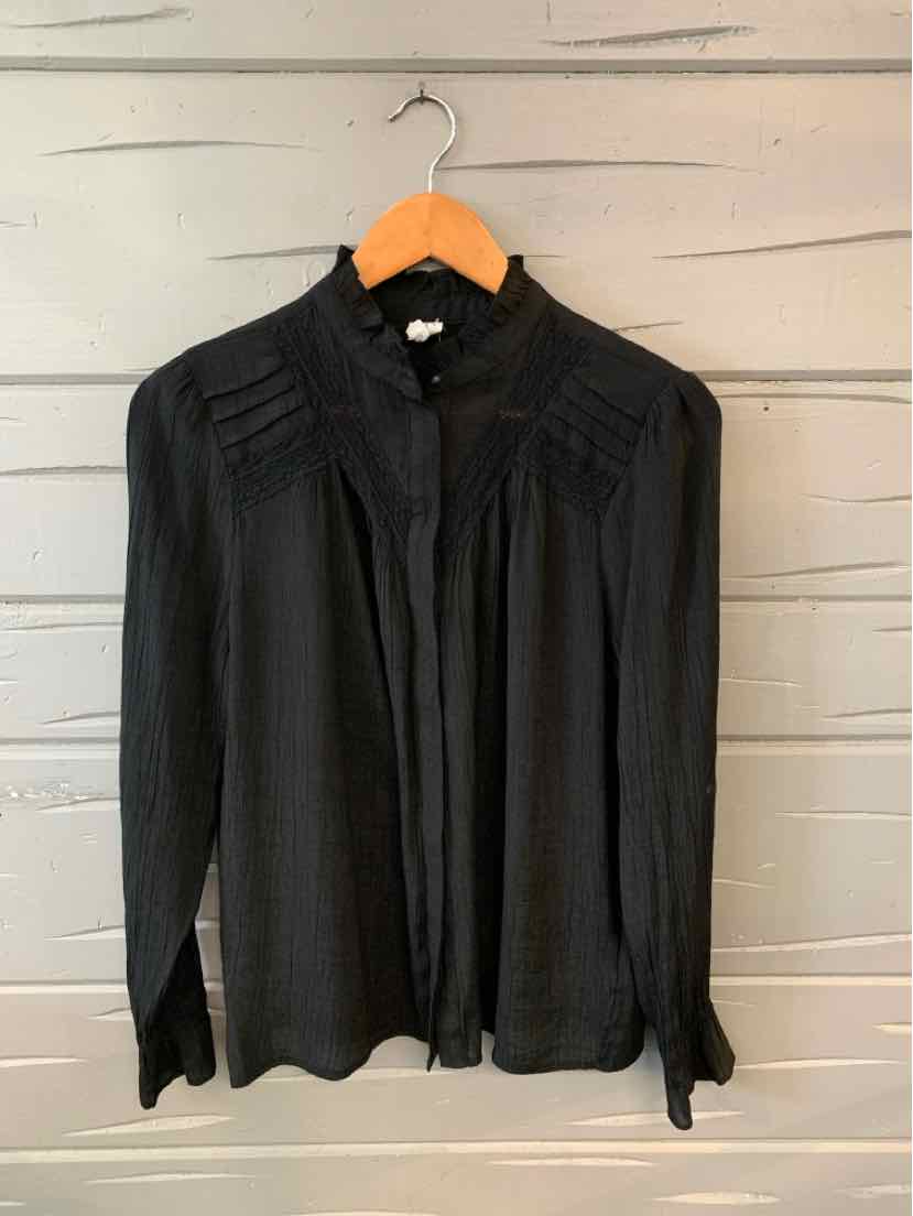 Black long-sleeve blouse with pleated yoke and button-up front on wooden hanger.