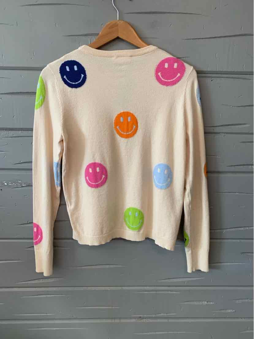 Cream long-sleeve sweater with colorful smiley face prints in pink, green, blue, orange, and navy.