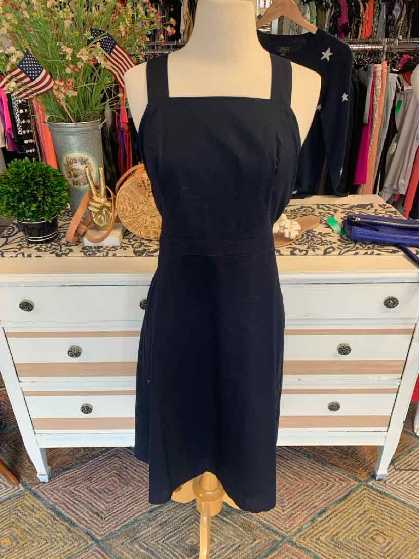 Black sleeveless square-neck dress with fitted waist on a mannequin.