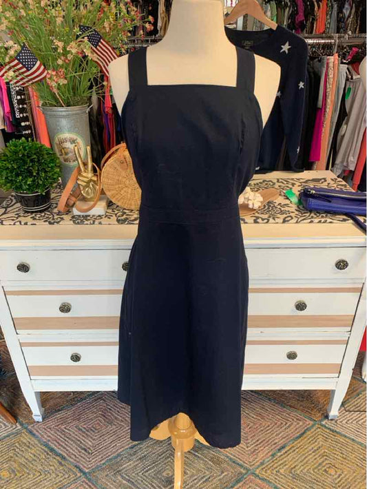 Black sleeveless square-neck dress with fitted waist on a mannequin.