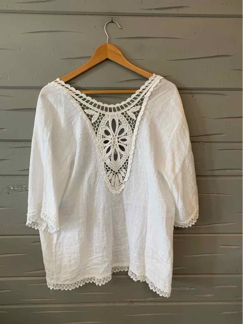 White cotton blouse with three-quarter sleeves and intricate crochet lace detail on the back neckline and hem.
