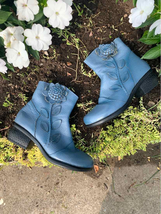 Blue ankle boots with rounded toes, decorative stitching, and low block heels.