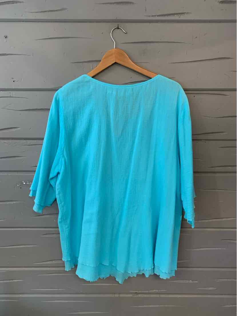 Light blue loose-fit long-sleeve top with a round neckline and soft fabric.