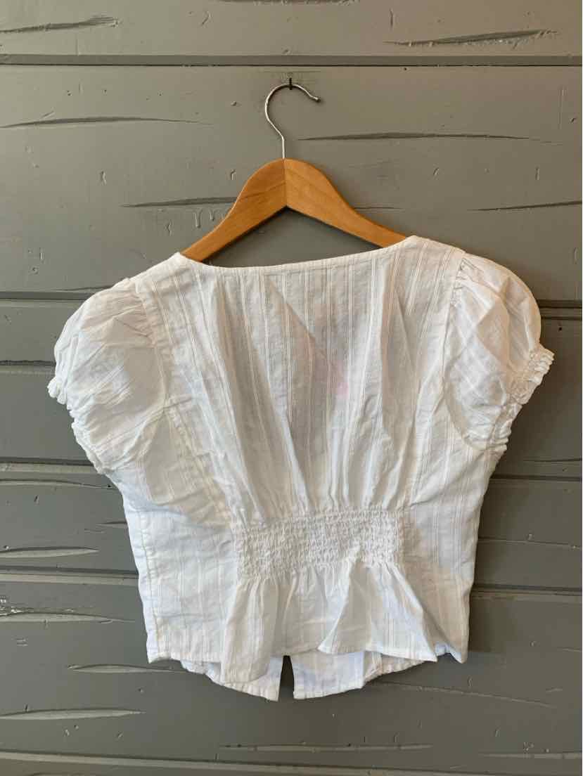 White short-sleeve blouse with ruched sleeves and a fitted waist on wooden hanger.