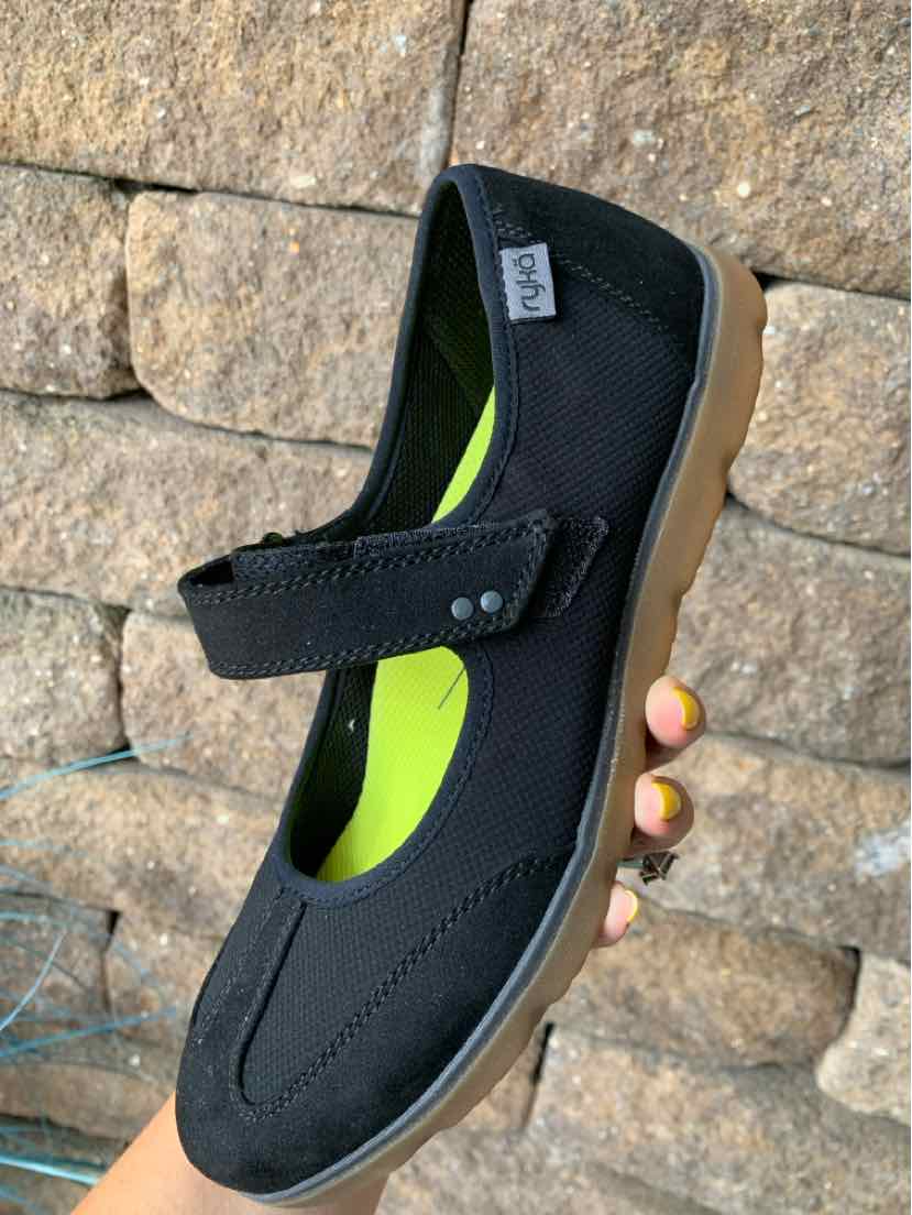 Black athletic Mary Jane shoe with adjustable strap and tan rubber sole, size 8.5.