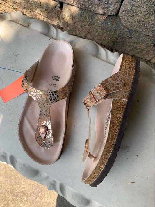 Women's size 36 Birkenstock sandals with tan leather straps featuring a metallic floral pattern and a cork sole.