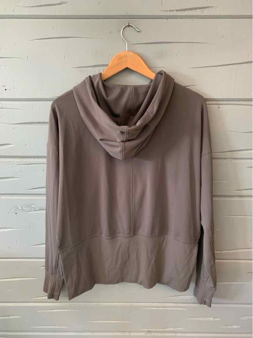 Taupe lightweight hoodie with long sleeves, front pockets, and a relaxed fit, hanging on a wooden hanger.