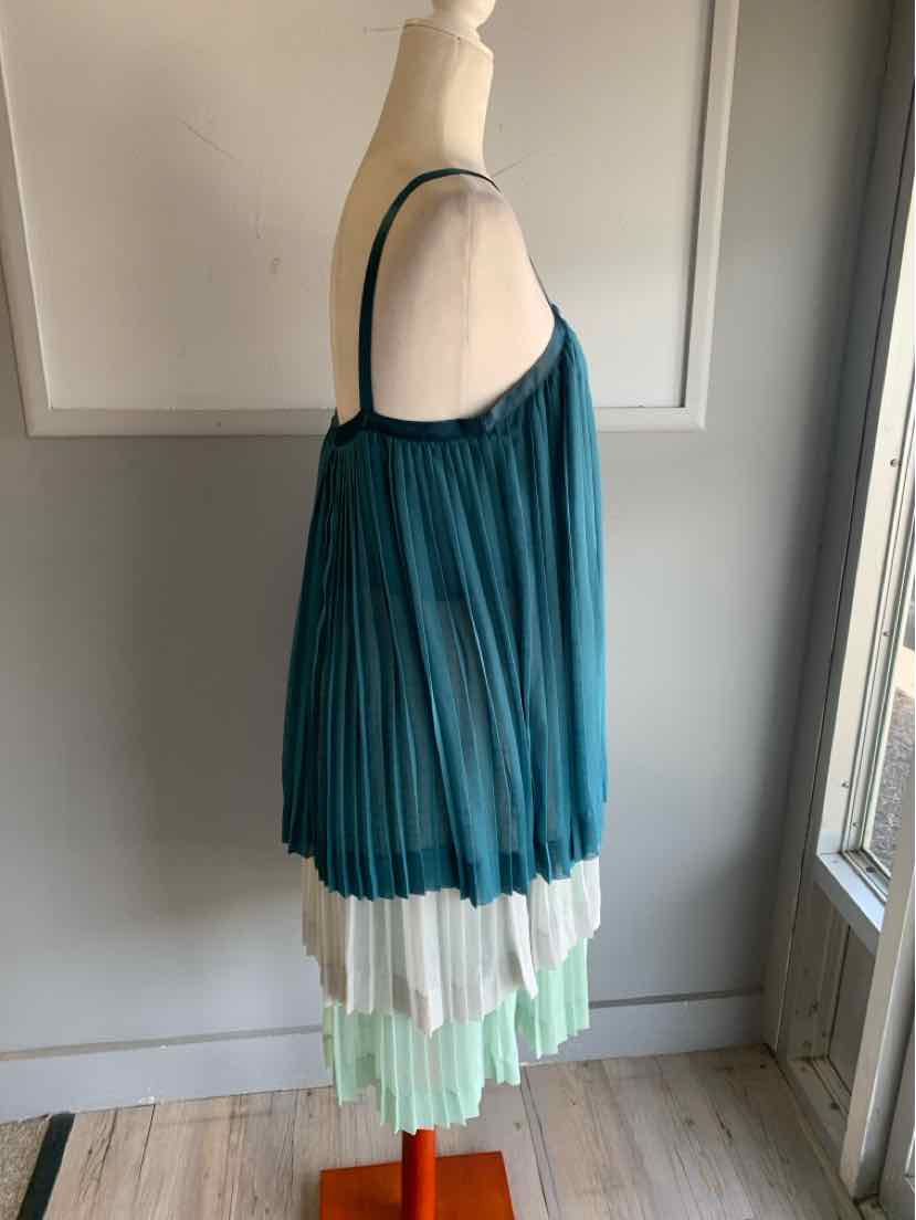 Sleeveless teal pleated dress with layered skirt in white and mint green, size 10, hanging on mannequin.