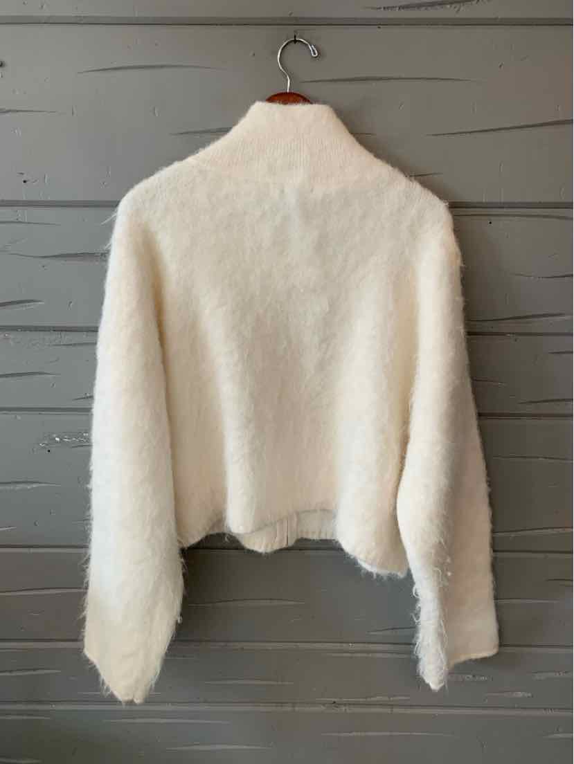Cream white fuzzy cropped sweater with a high neckline and long sleeves, shown from the back.