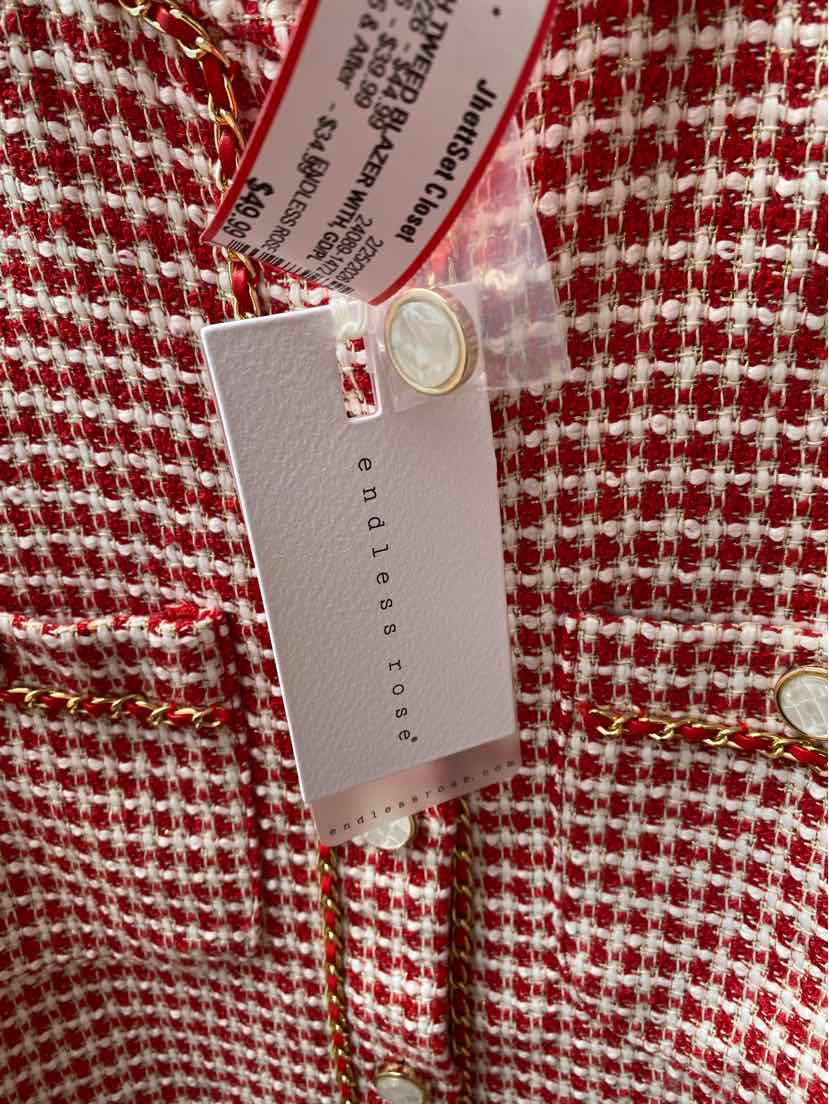 Red and white tweed blazer with gold buttons and fabric brand tag attached.