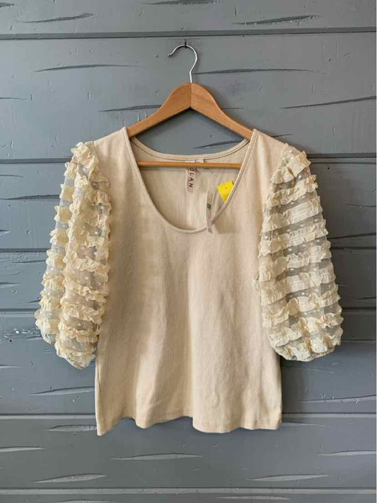Tan blouse with scoop neckline and puffed lace sleeves featuring floral patterns.