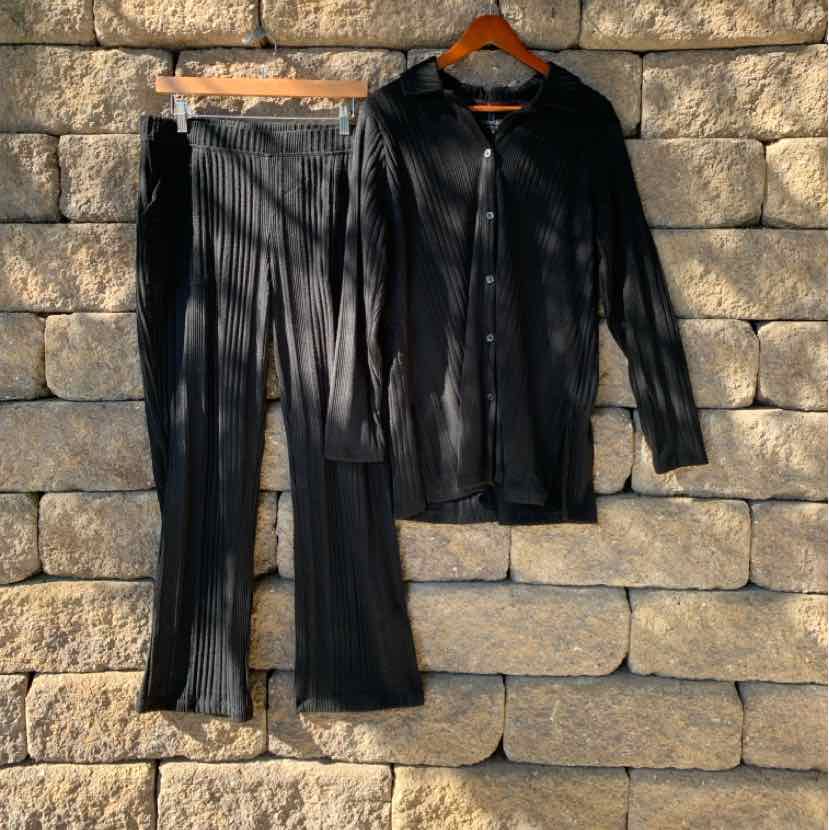 Black ribbed long-sleeve button-up top and matching ribbed pants set on wooden hangers.