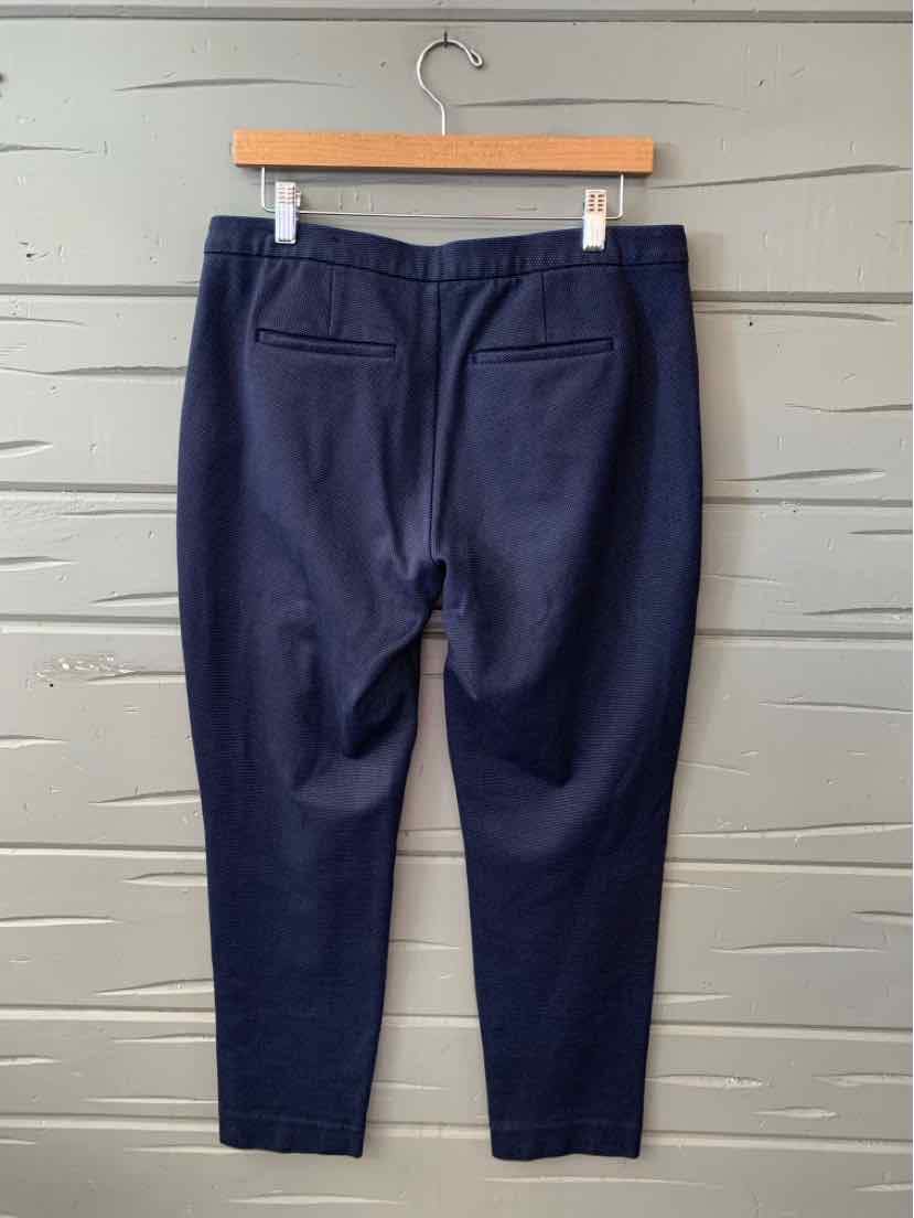 Navy blue tailored trousers with back welt pockets, tapered legs, and a flat waistband.