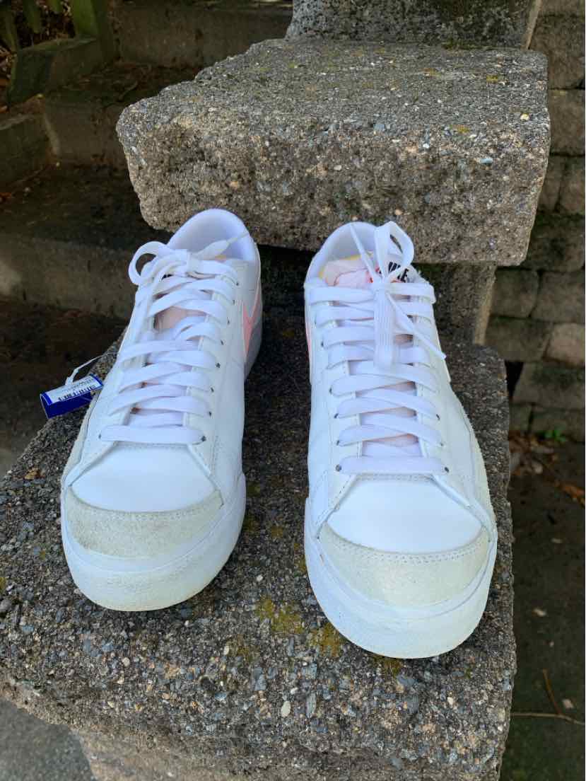 Pair of white Nike high-top sneakers with white laces, rounded toes, and padded collars.