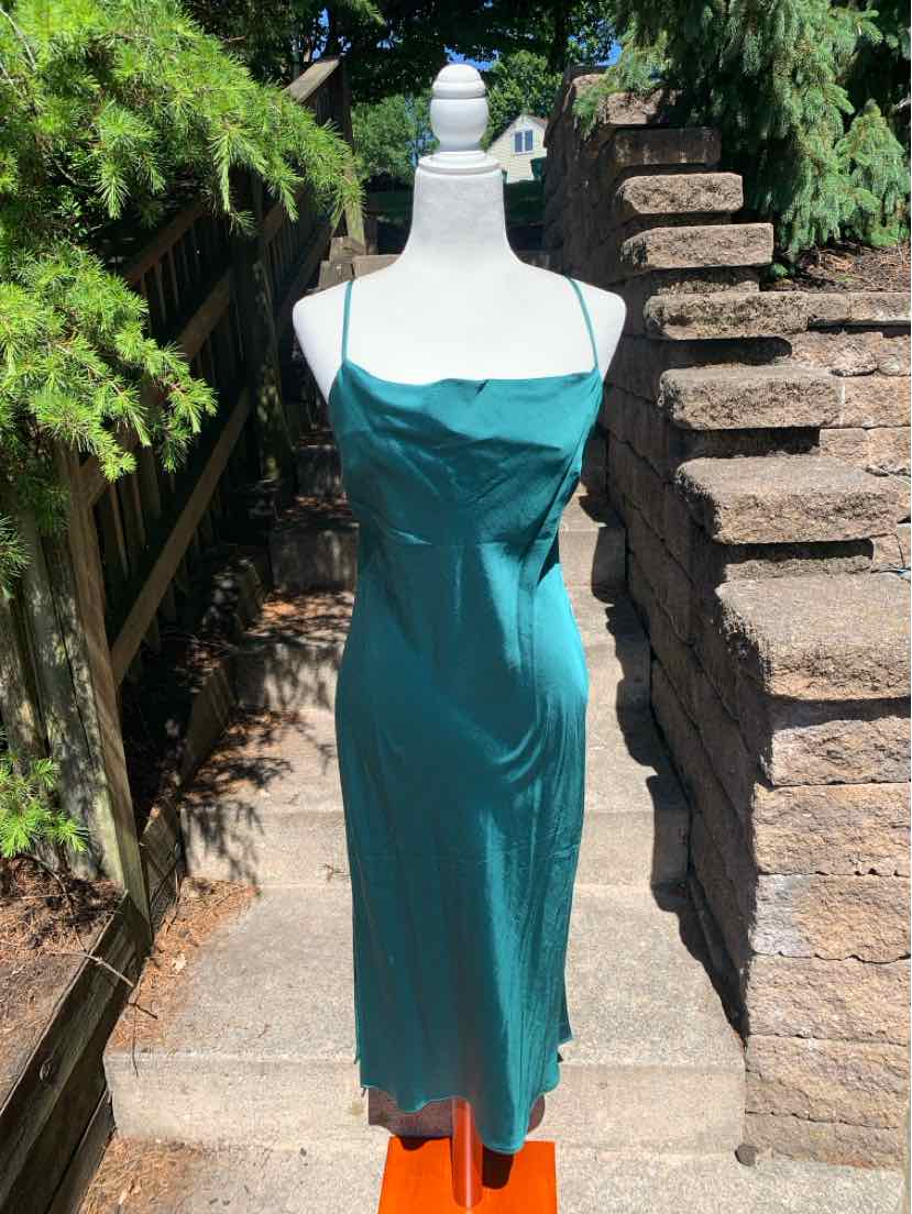 Teal satin midi dress with spaghetti straps and straight neckline on mannequin outdoors.