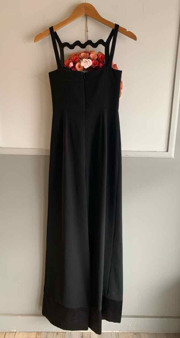 Black sleeveless jumpsuit with wide legs, floral embroidered bodice, and fitted waist on wooden hanger.