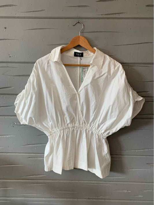 White loose-fit blouse with wide puff sleeves, cinched waist, and V-neck collar.