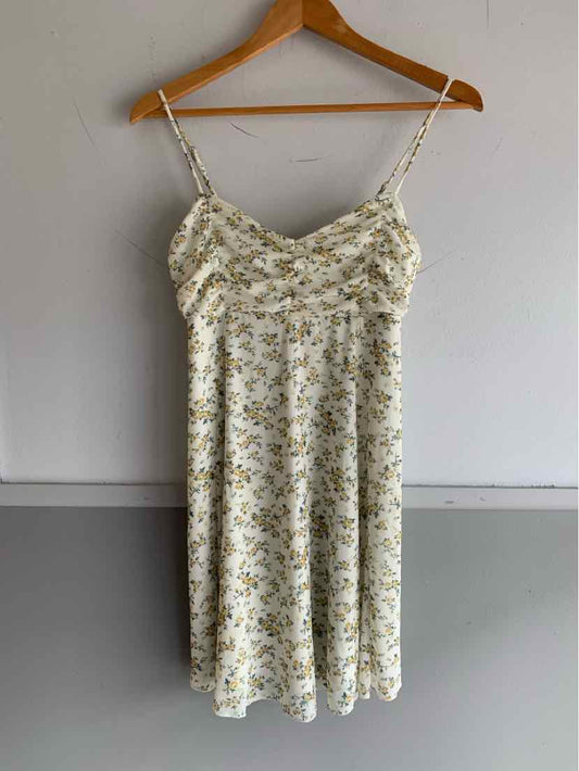 Light beige floral slip dress with thin adjustable straps and subtle ruched bust detail.