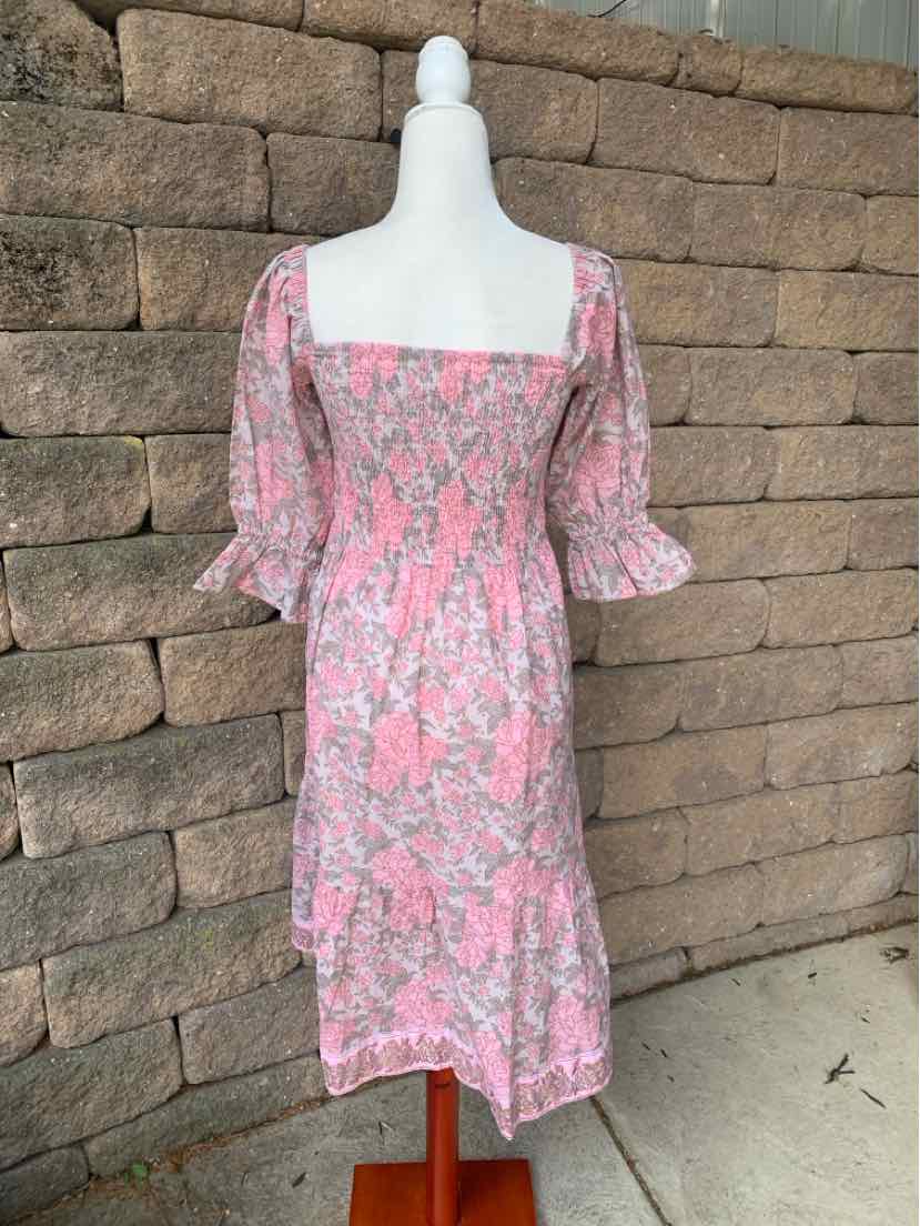 Pink floral knee-length dress with puff sleeves and square neckline on a mannequin.