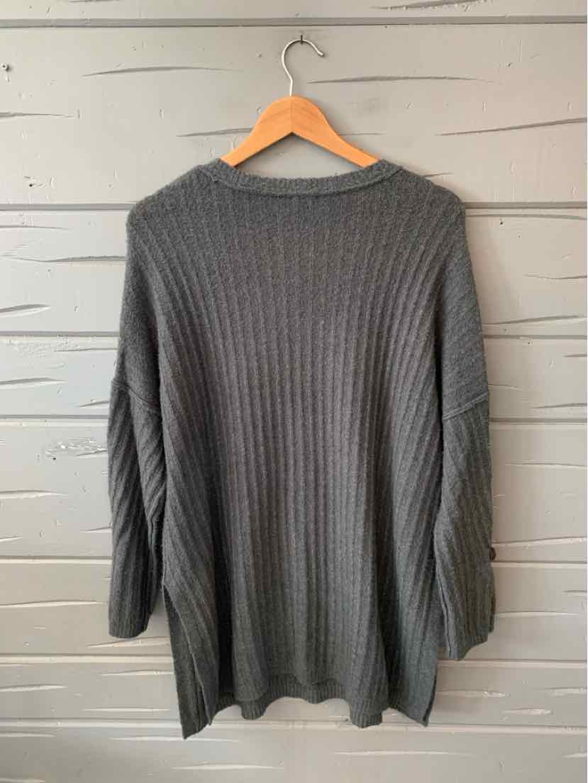 Gray ribbed knit long-sleeve sweater with round neckline hanging on wooden hanger.