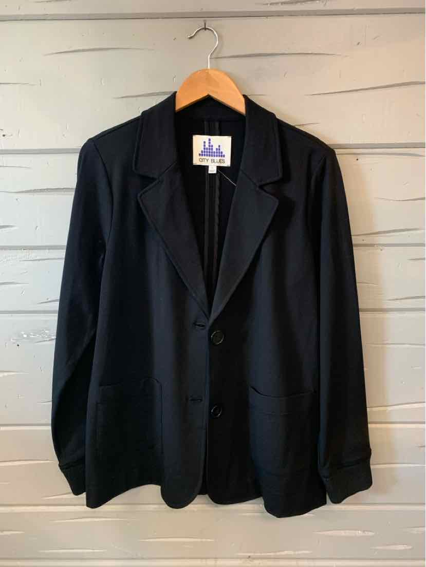 Black oversized blazer with notch lapels, single-button closure, and long sleeves on wooden hanger.