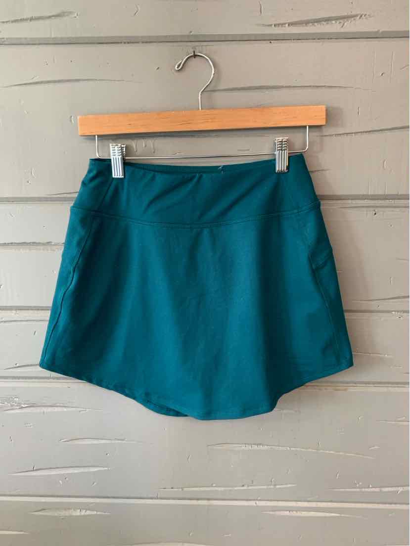 Teal lightweight athletic skirt with wide waistband in size XS hanging on wooden hanger.