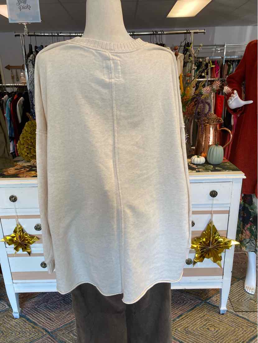 Light beige sleeveless tunic top with a loose fit and a subtle seam down the center back.