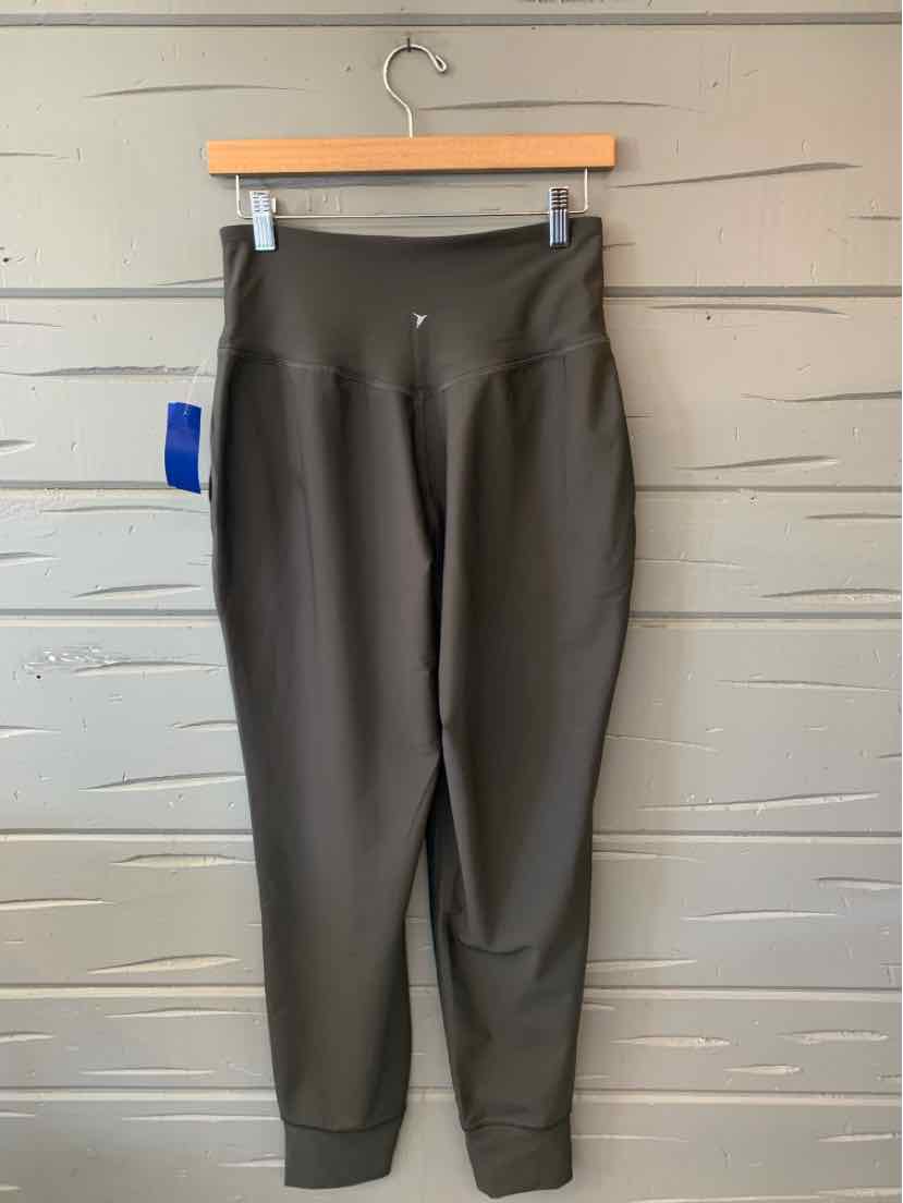 Dark gray Old Navy women's pants with a smooth finish, tapered legs, and elastic ankle cuffs hanging on a wooden hanger.