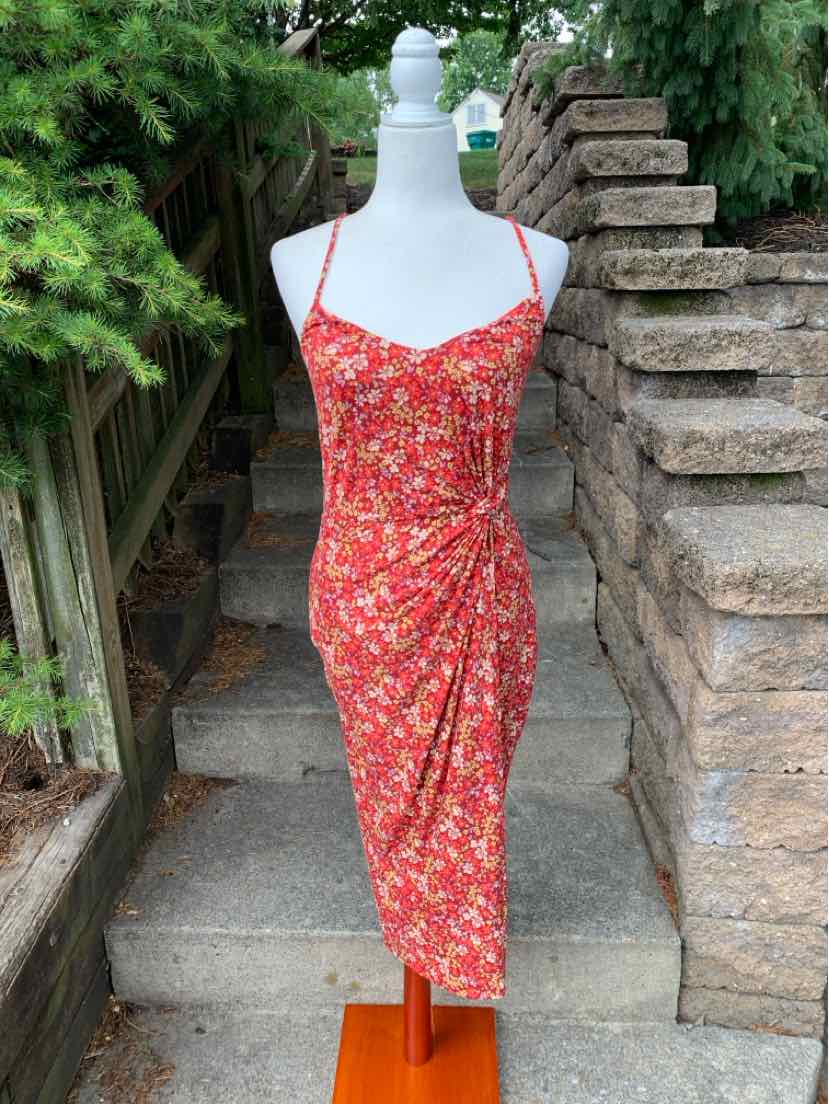 Red floral midi dress with ruched side detail and thin spaghetti straps on mannequin.