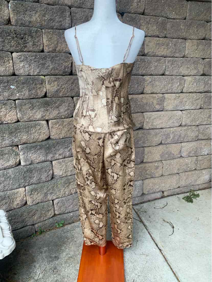 Beige snake print satin camisole and matching wide-leg pants set on mannequin against stone wall background.