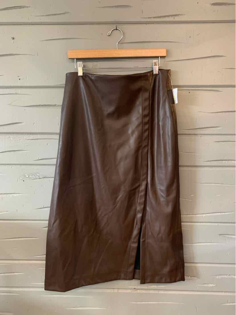 Brown faux leather midi skirt with a front slit and straight silhouette hanging on a wooden hanger.