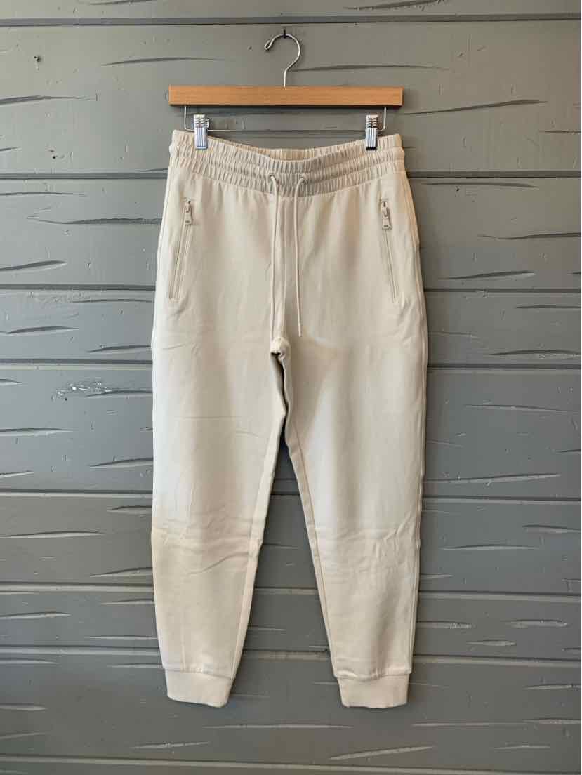 Cream Old Navy pants with an elastic drawstring waist, side pockets, and tapered legs.