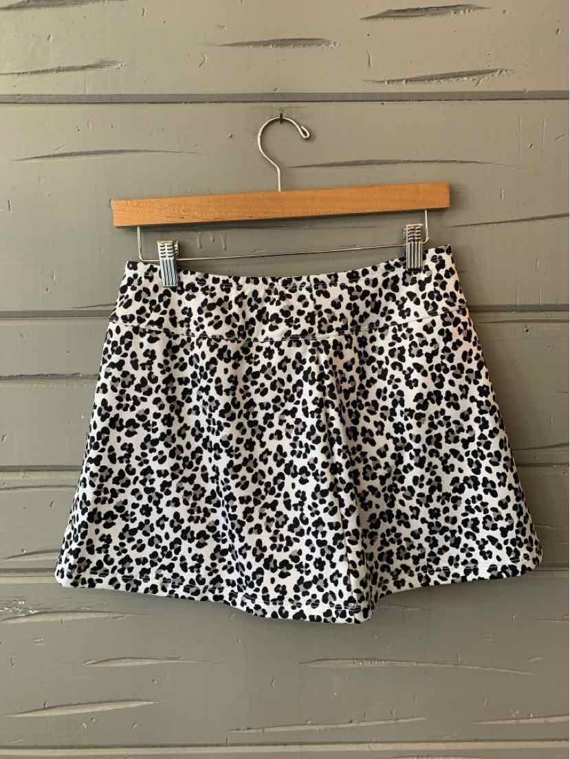 White and black leopard print skirt with elastic waistband hanging on wooden hanger.