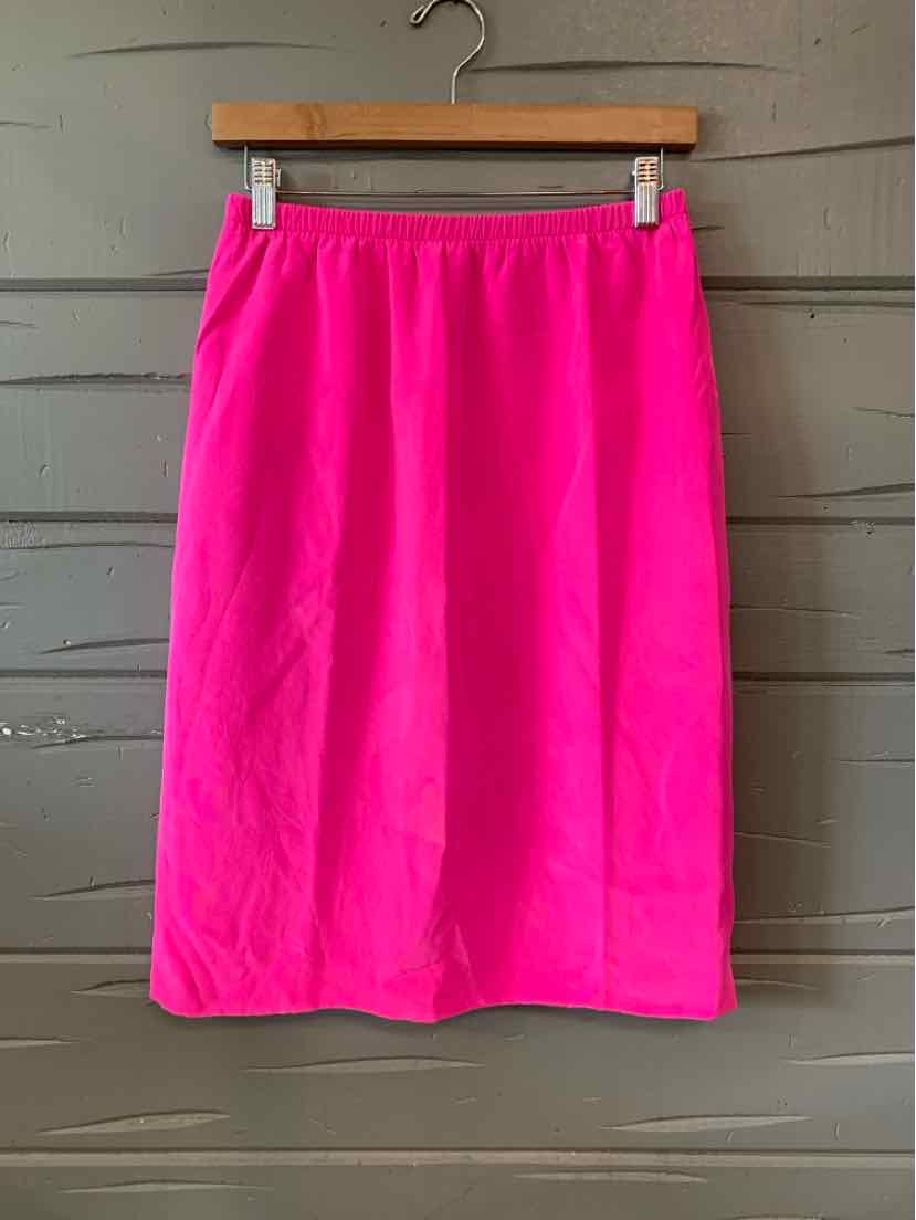 Bright pink knee-length skirt with a straight cut and elastic waistband hanging on a wooden hanger.