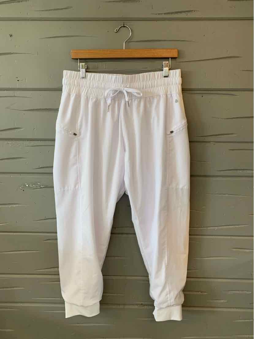 White cropped jogger pants with elastic waistband, drawstring, and side zip pockets.