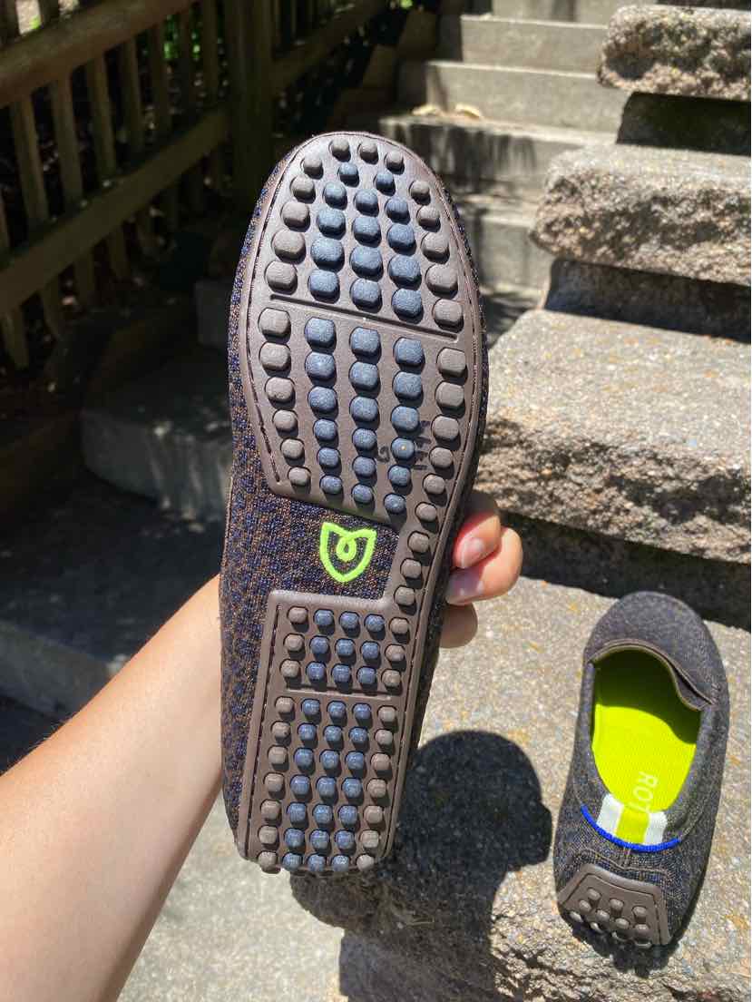 Brown cheetah print flat shoe with flexible rubber sole featuring circular treads and green logo on size 10.5 W Rothy's BR.