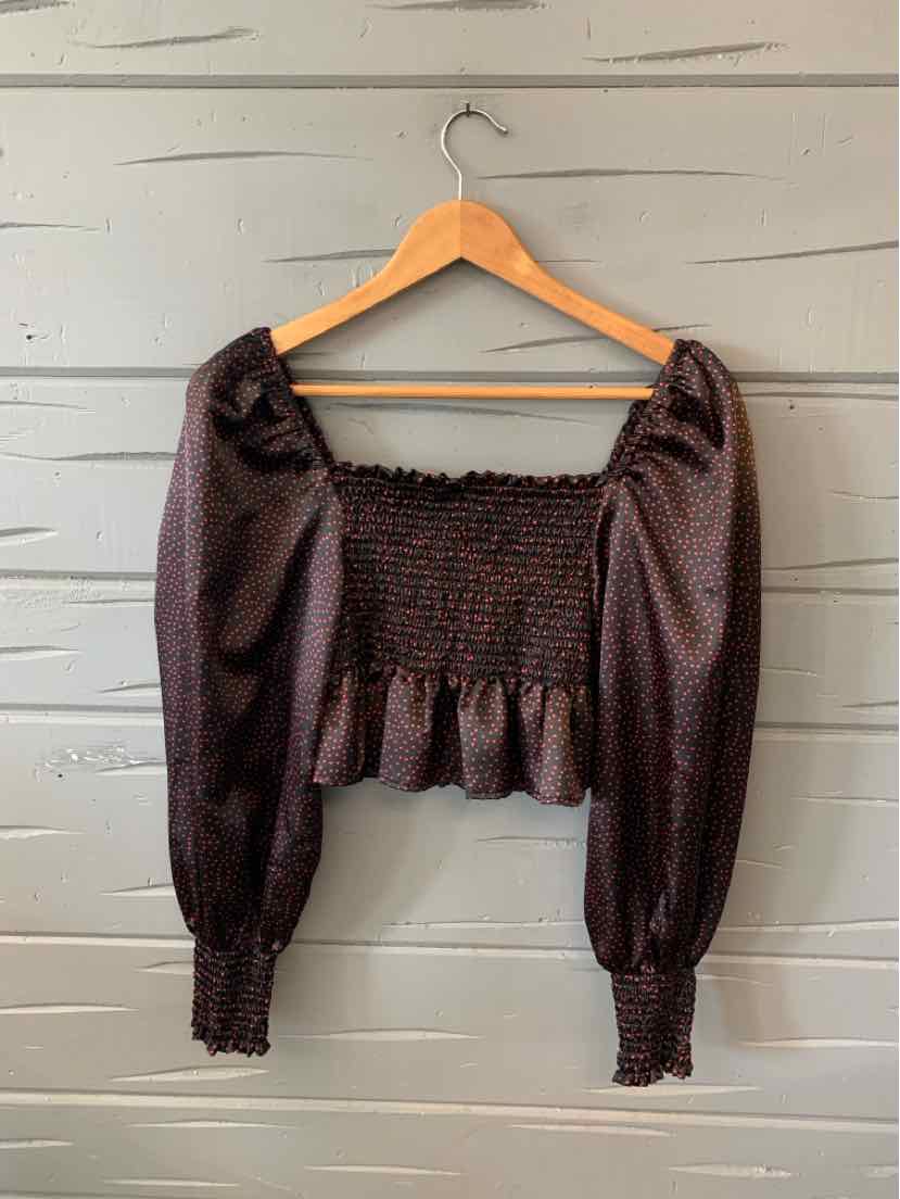 Black long-sleeve cropped blouse with smocked bodice, puffed sleeves, and ruffled hem.